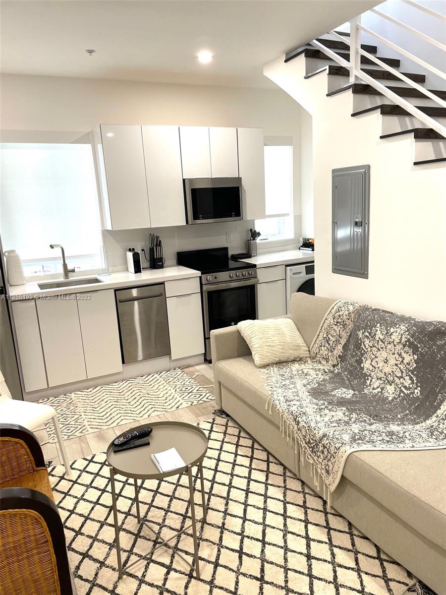 1610 Euclid Avenue, Unit A110 Miami Beach, FL 33139 - Photo 4 of 19 a kitchen with granite countertop a stove a sink and a microwave