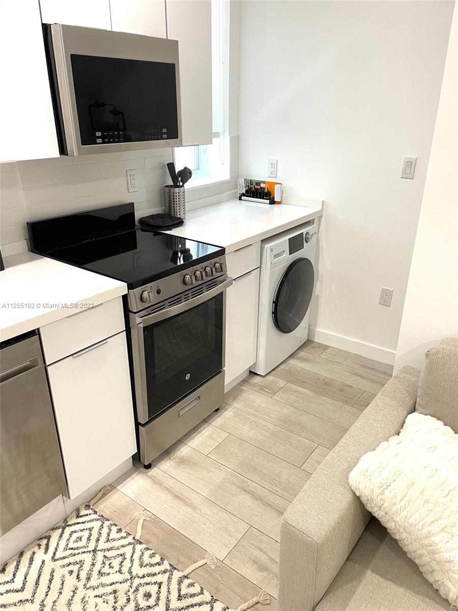 1610 Euclid Avenue, Unit A110 Miami Beach, FL 33139 - Photo 6 of 19 a view of washer and dryer with a flat screen tv