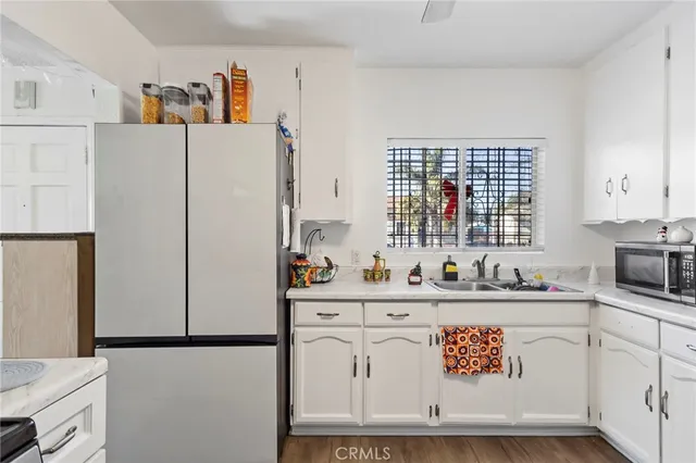 a kitchen with stainless steel appliances a stove a sink cabinets and a window
