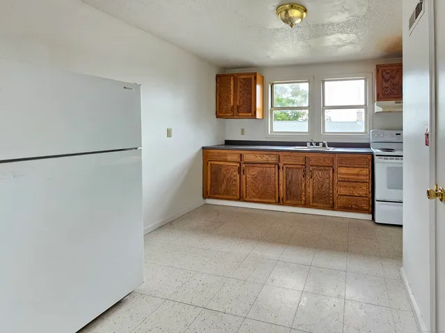 a view of a kitchen with a sink and a refrigerator