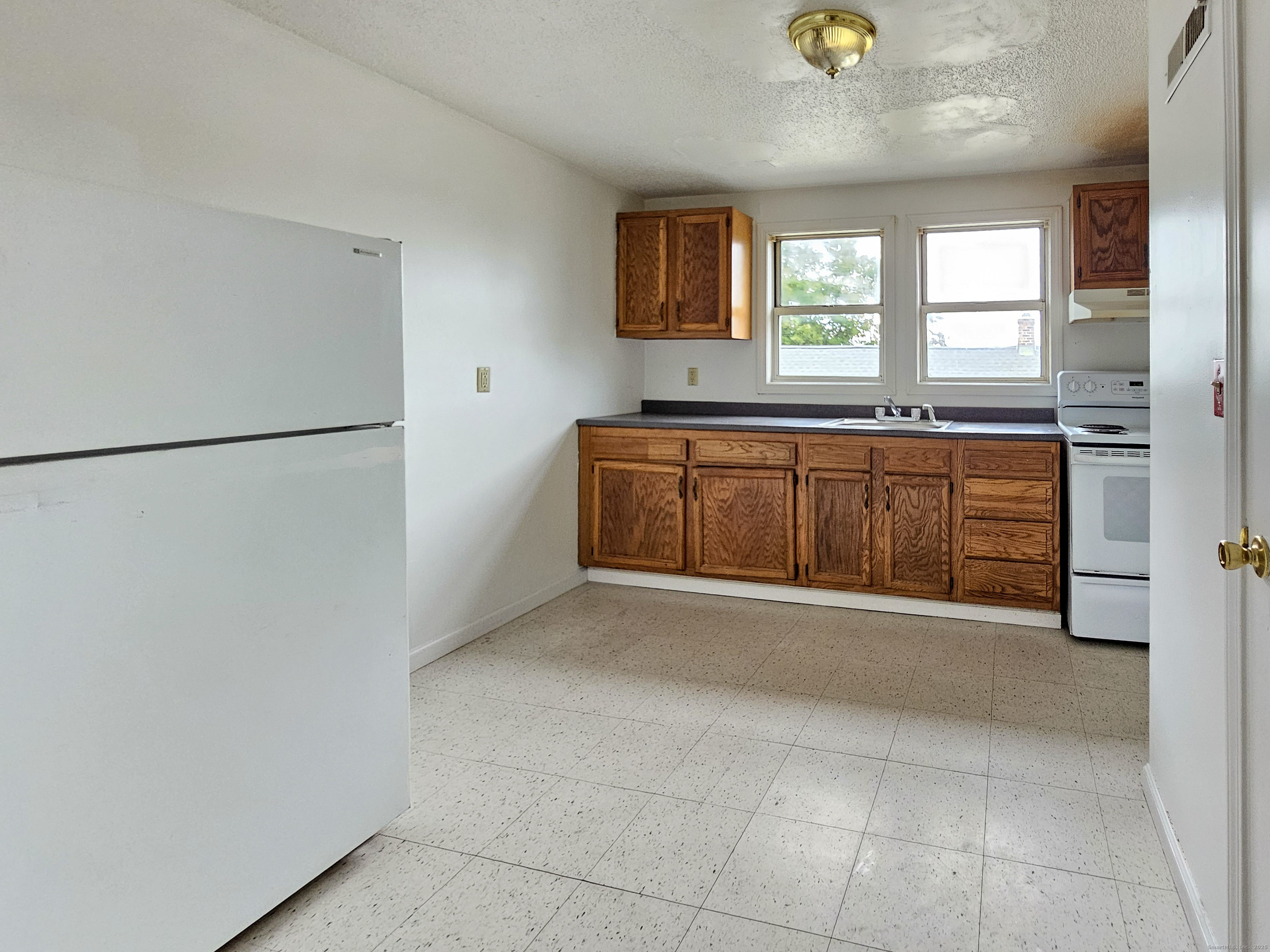54 Washington Street, Unit 3 Wallingford, CT 06492 - Photo 2 of 9 a view of a kitchen with a sink and a refrigerator