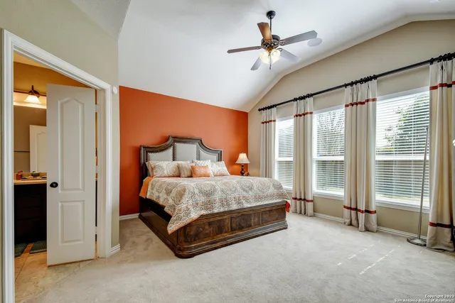a spacious bedroom with a bed and a chandelier