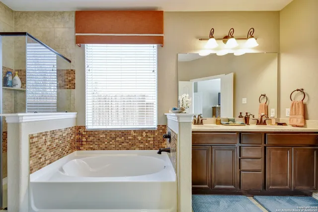 a bathroom with a tub sink and mirror