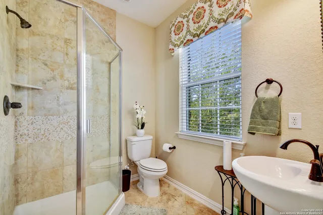 a bathroom with a toilet sink a shower and a mirror