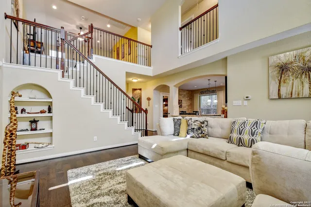 a living room with couches and a dining table with wooden floor
