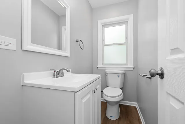 a bathroom with a toilet sink and mirror