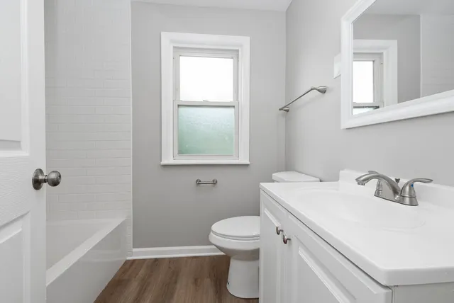 a bathroom with a sink toilet vanity and bathtub
