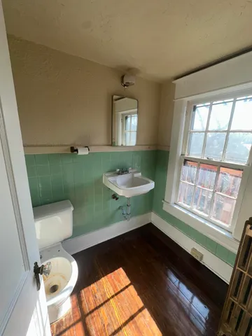 a bathroom with a sink a toilet and a mirror