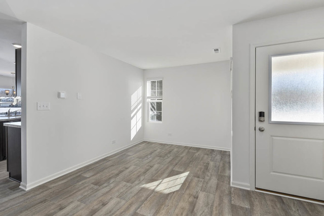 18 West Lake Court Cary, IL 60013 - Photo 4 of 21 an empty room with wooden floor and windows