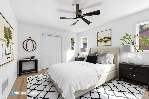 a bedroom with a bed a dresser and painting on the wall