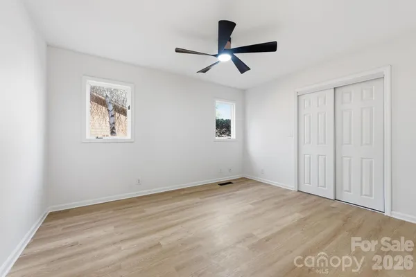 a view of empty room with wooden floor