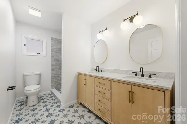 a bathroom with a double vanity sink toilet and a mirror