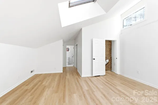a view of a room with wooden floor and bathroom
