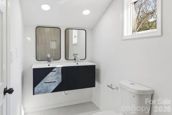a bathroom with mirror and window