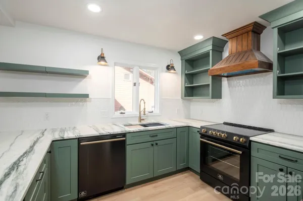 a kitchen with stainless steel appliances granite countertop a sink stove and cabinets
