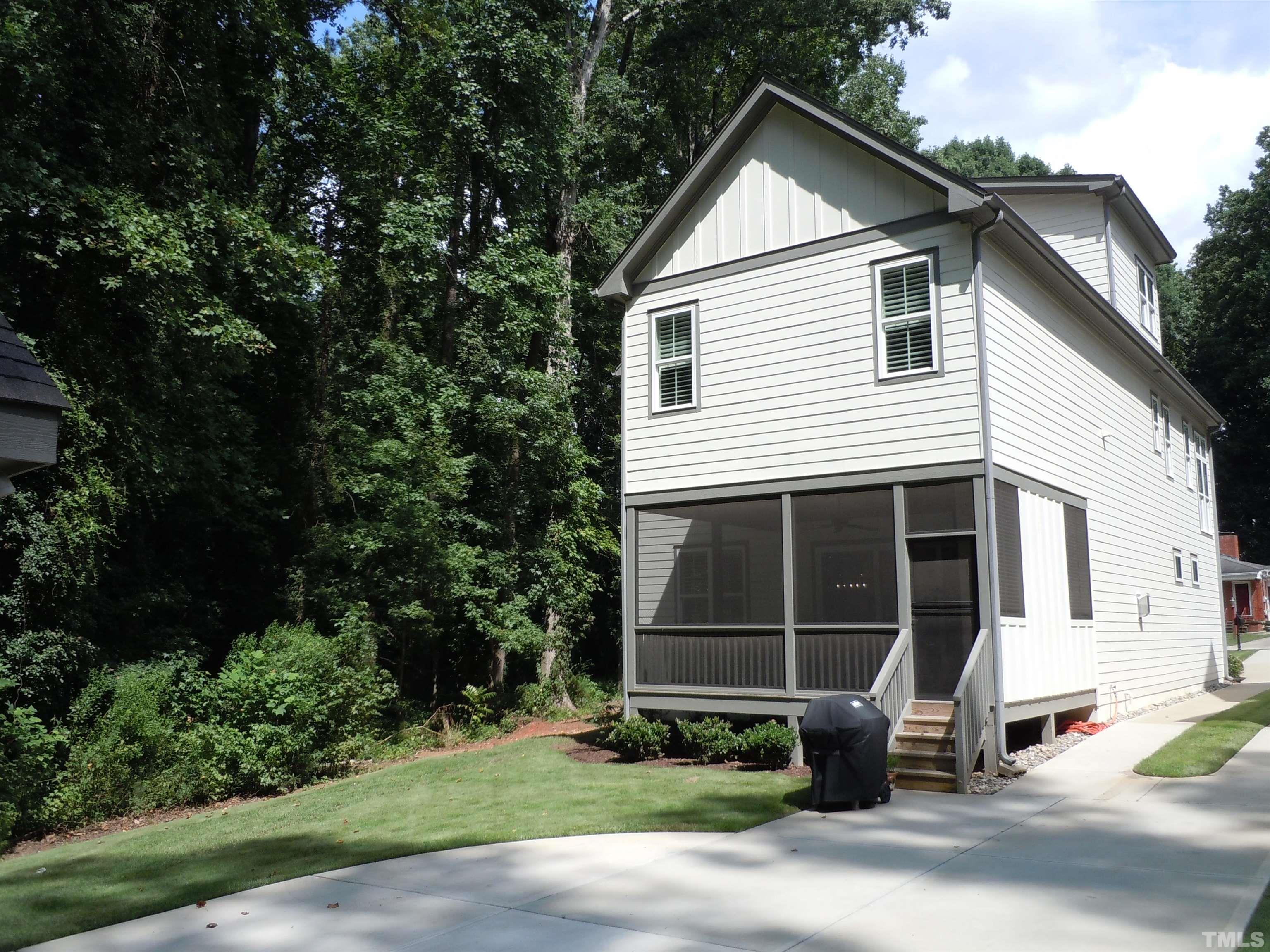 1009 Marilyn Drive Raleigh, NC 27607 - Photo 3 of 36 a view of a white house with large windows and a small yard