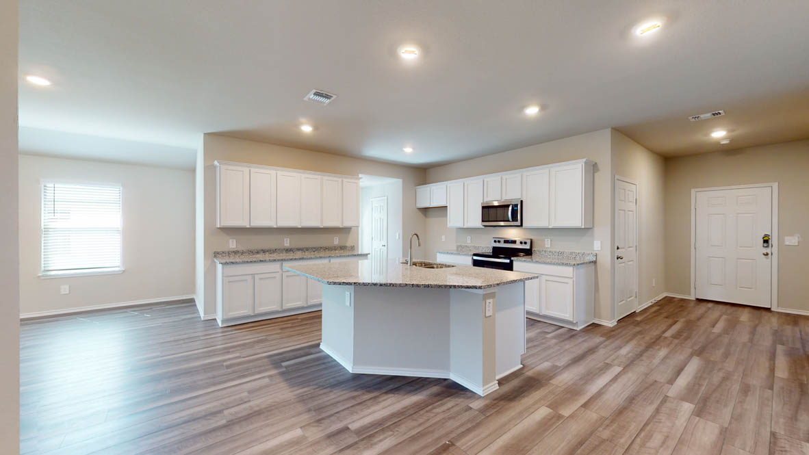 509 Hector Loop Georgetown, TX 78626 - Photo 10 of 31 An open-concept kitchen and living area feature a spacious central island and wood-look flooring.