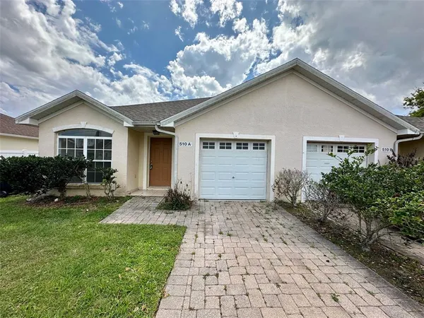 a front view of a house with a garden and yard