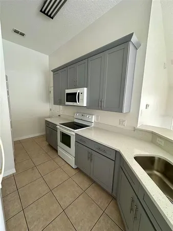 a kitchen with a sink a stove and cabinets