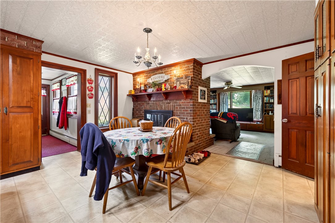7780 Cold Springs Road Bath, NY 14810 - Photo 6 of 50 An inviting brick fireplace accents this spacious dining area with textured ceilings and tile flooring.