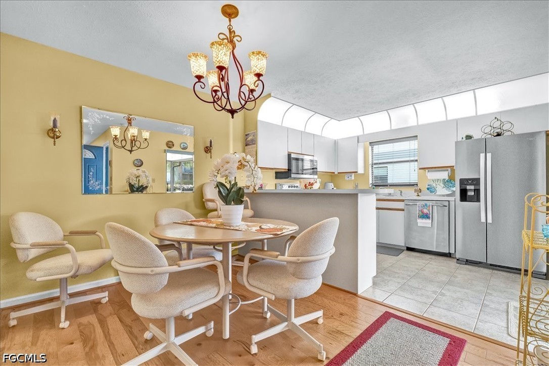 707 Hoover Dike Road, Unit 904 Clewiston, FL 33440 - Photo 20 of 41 a dining room with stainless steel appliances kitchen island granite countertop a table chairs and a refrigerator