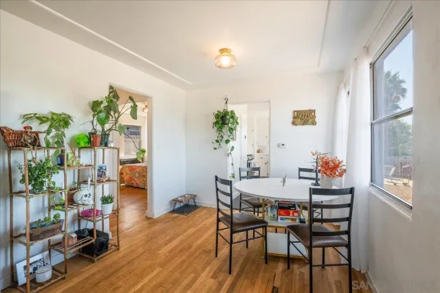 a view of a hallway with wooden floor and dining room