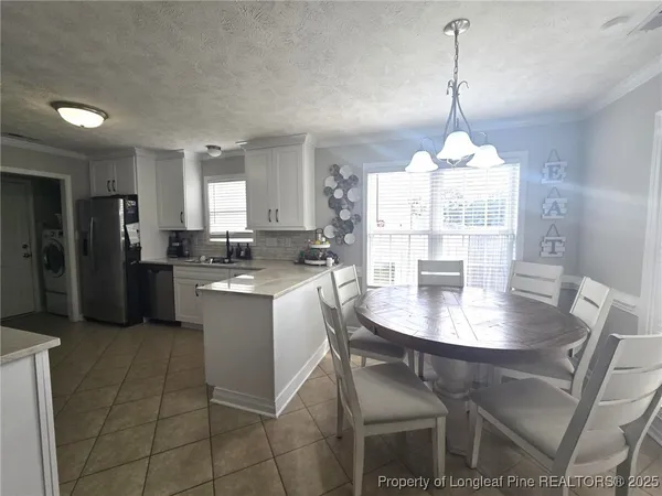 a kitchen with stainless steel appliances granite countertop a stove a refrigerator a kitchen island a stove a dining table and chairs