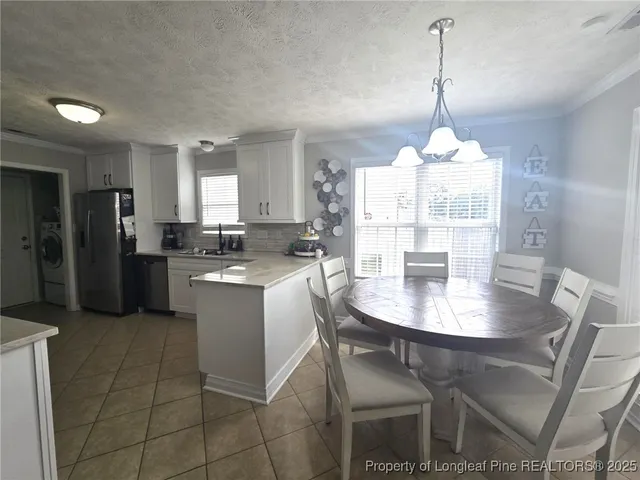 a kitchen with stainless steel appliances granite countertop a stove a refrigerator a kitchen island a stove a dining table and chairs