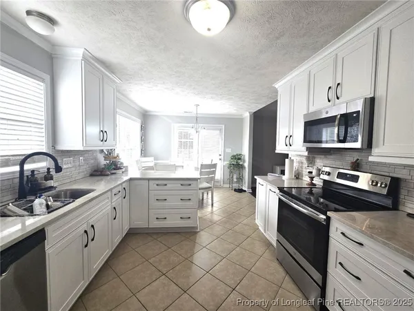 a kitchen with stainless steel appliances a sink stove and cabinets
