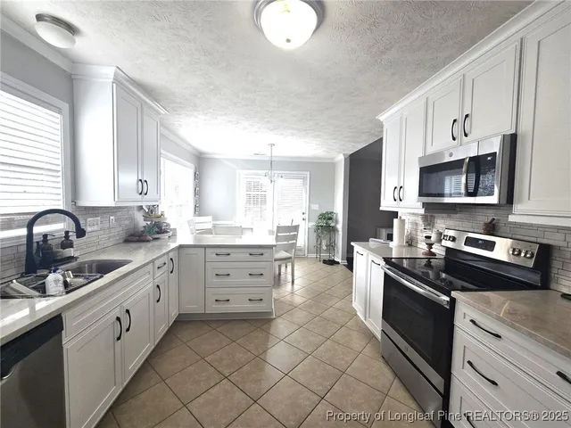a kitchen with stainless steel appliances a sink stove and cabinets