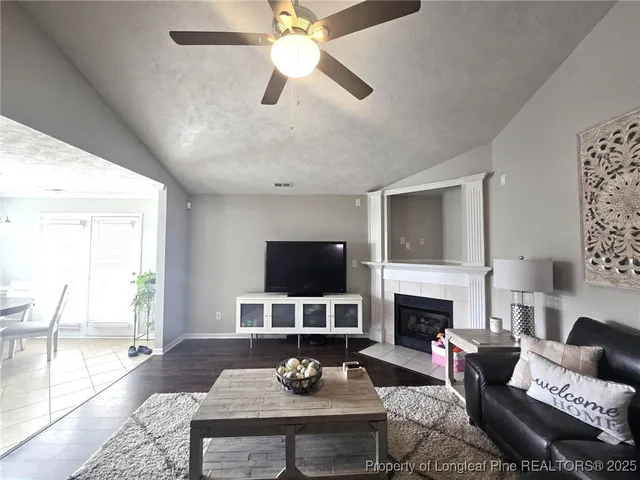 a living room with furniture a fireplace and a flat screen tv