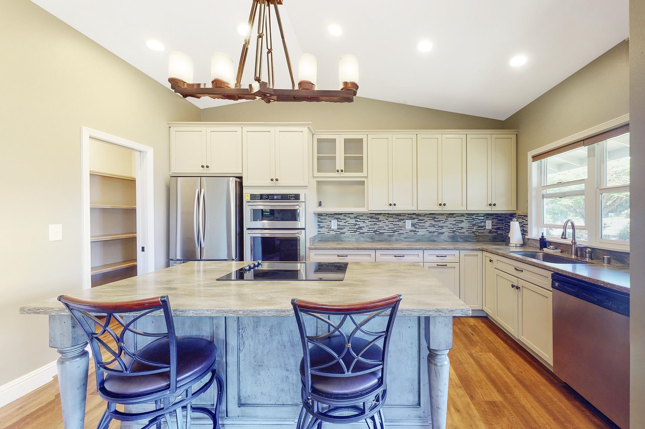 1480 Hog Back Road, Unit 1480 HOG BACK ROAD Haiku, HI 96708 - Photo 17 of 29 a kitchen with stainless steel appliances granite countertop a kitchen island a stove a table and chairs