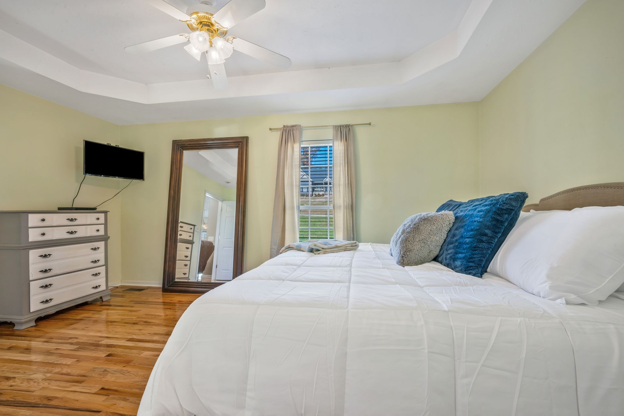 1427 St Paul Road Charlotte, TN 37036 - Photo 16 of 38 a bedroom with a large bed and a flat tv screen on dresser