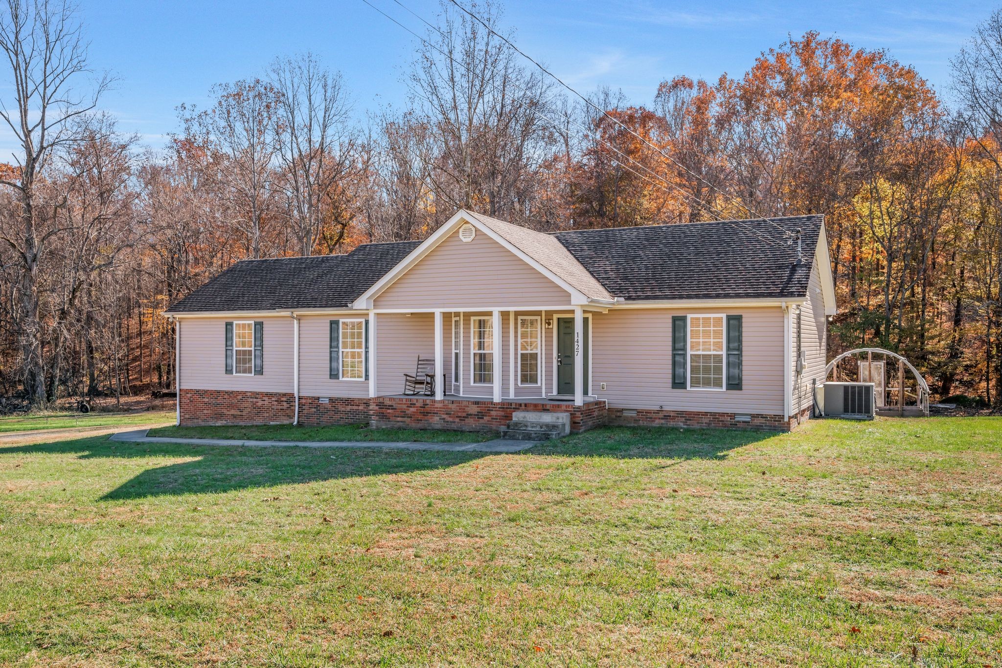 1427 St Paul Road Charlotte, TN 37036 - Photo 28 of 38 a front view of a house with a garden and trees