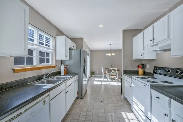 a dining room with furniture a chandelier and wooden floor