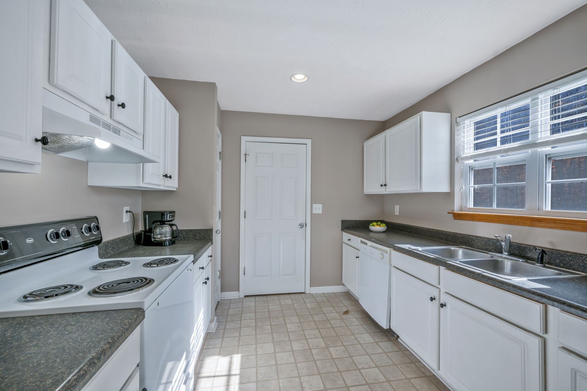 1427 St Paul Road Charlotte, TN 37036 - Photo 10 of 38 a kitchen with stainless steel appliances granite countertop a sink stove and cabinets