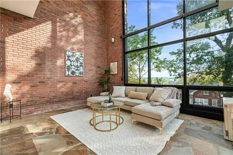 a living room with furniture and a floor to ceiling window