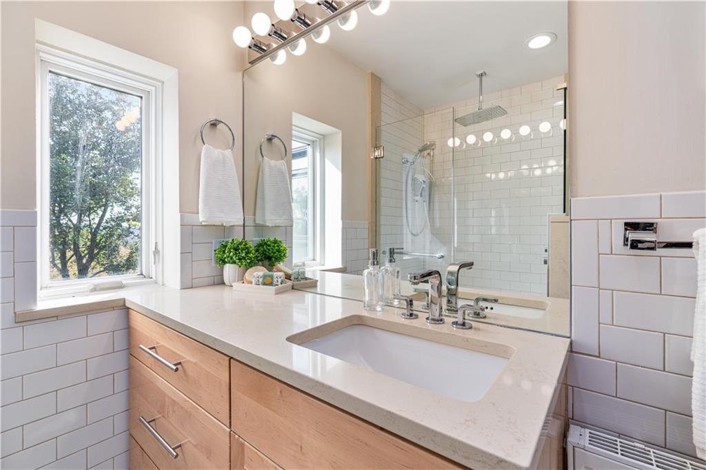 943 Wellesley Road Pittsburgh, PA 15206 - Photo 21 of 34 a bathroom with a sink a large mirror and a shower