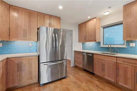 a kitchen with stainless steel appliances granite countertop a refrigerator and a stove top oven