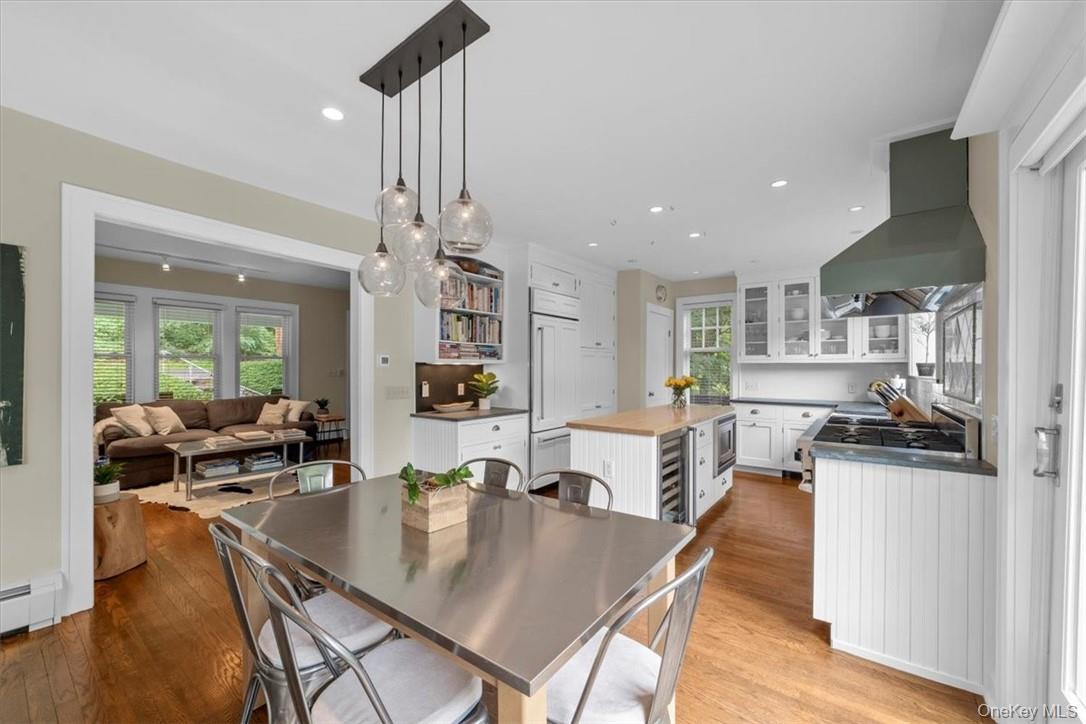 28 Inningwood Road Ossining, NY 10562 - Photo 15 of 37 Dining space featuring light wood-type flooring, baseboard heating, wine cooler, and a wealth of natural light