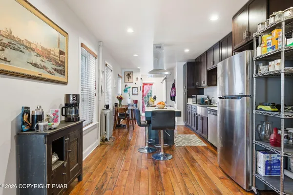 a kitchen view with stainless steel appliances refrigerator dining table and chairs