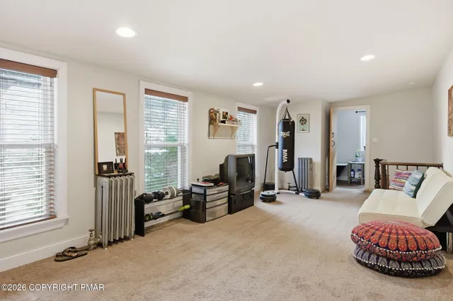 a living room with furniture a air conditioner vent and a window