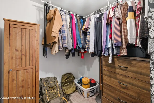 a view of walk in closet with clothes and shoes