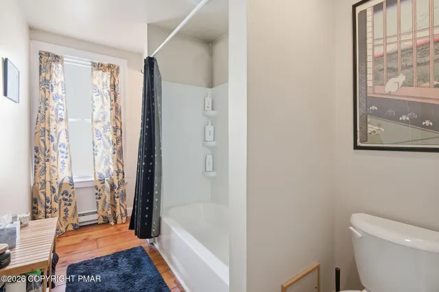 a bathroom with a granite countertop bathtub shower and toilet