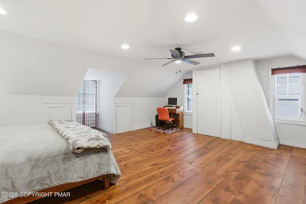 a bedroom with a bed and a ceiling fan