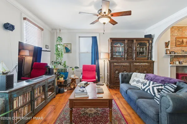 a living room with furniture stairs and a window