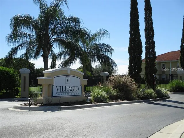 a sign board with a small yard and palm trees