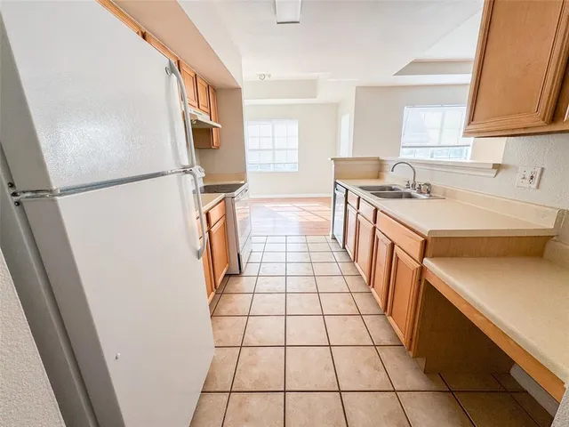 a kitchen with a sink a refrigerator and a stove