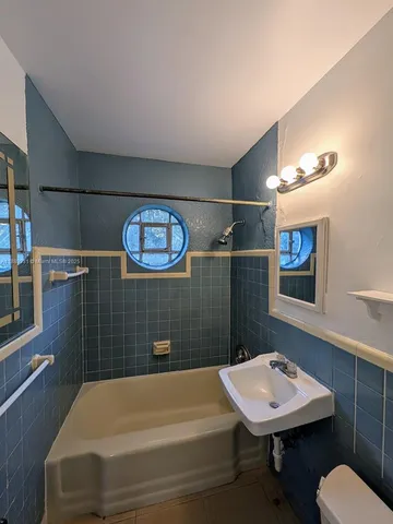 a bathroom with a sink a light fixture and a toilet