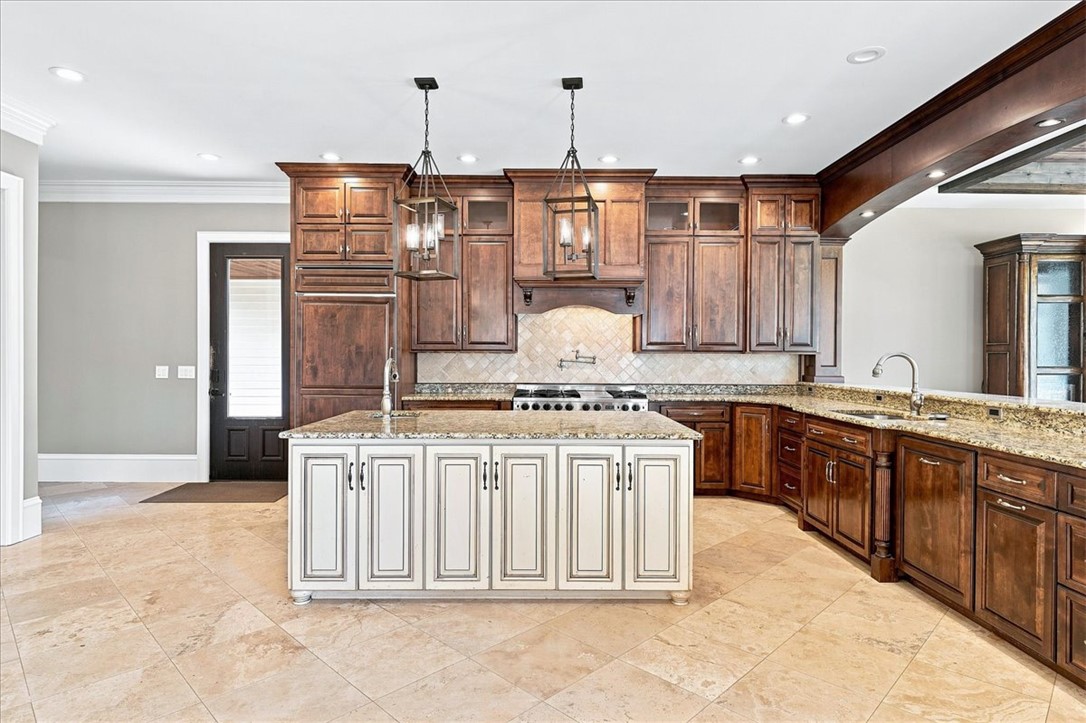 181 Sentell Road Williamston, SC 29697 - Photo 14 of 46 A spacious kitchen features warm wood cabinetry, stone countertops, and high-end appliances.